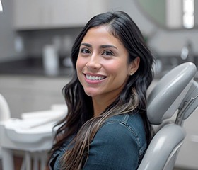 Happy young woman in dental treatment chair