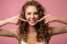 Smiling young woman pointing at her braces in Woodbridge