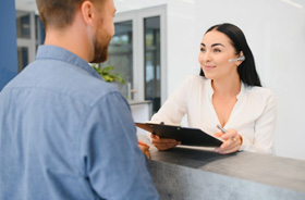 Patient speaking with front office team member in dental office