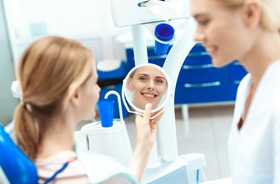 cosmetic dental patient admiring smile after gum contouring