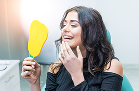 Woman looking at smile in mirror