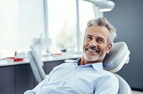 Gray-haired man smiling in dental chair
