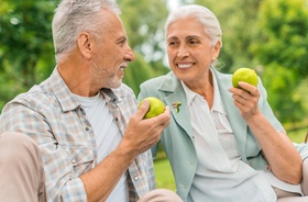 senior couple eating apples