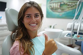 Happy dental patient making thumbs up gesture