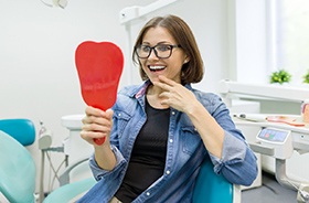 young woman admiring her new dental implants in Woodbridge
