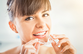 Woman placing Invisalign tray