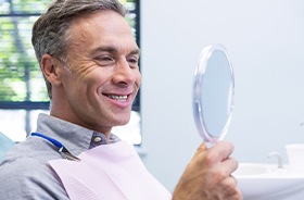 Patient smiling into mirror