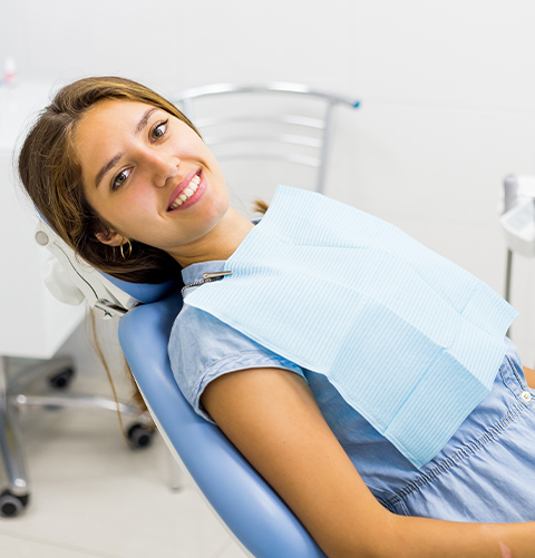 Smiling woman leaning back in dental exam chair