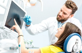 dentist and patient looking at monitor discussing smile makeover