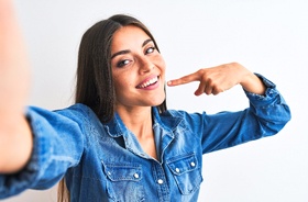 confident woman taking selfie and showing off beautiful teeth