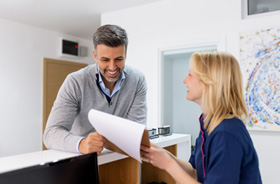 Dental team member assisting patient at front desk