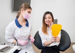 Woman admiring her smile after braces removal in Woodbridge