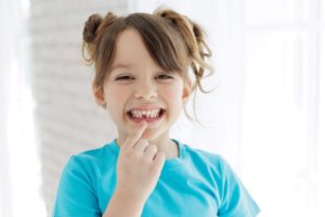 Smiling child showing spot in her mouth with missing tooth