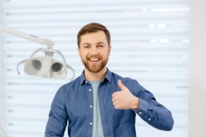 Man in dental office making thumbs up gesture