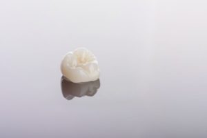 Dental crown isolated on reflective surface