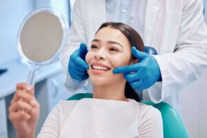 Dental patient holding hand mirror during cosmetic consultation