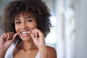 Woman flossing between her front teeth 